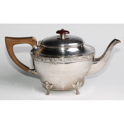 1139 - An Arts and Crafts silver three piece tea service, comprising teapot, hot water pot and sugar basin,... 