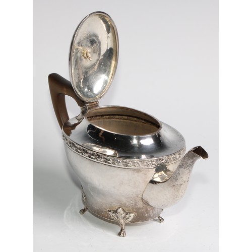 1139 - An Arts and Crafts silver three piece tea service, comprising teapot, hot water pot and sugar basin,... 