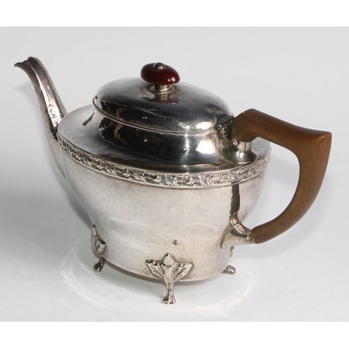 1139 - An Arts and Crafts silver three piece tea service, comprising teapot, hot water pot and sugar basin,... 