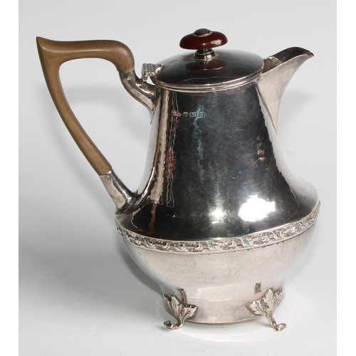 1139 - An Arts and Crafts silver three piece tea service, comprising teapot, hot water pot and sugar basin,... 