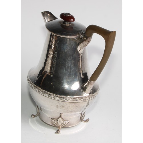 1139 - An Arts and Crafts silver three piece tea service, comprising teapot, hot water pot and sugar basin,... 