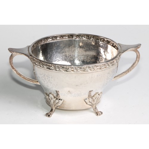 1139 - An Arts and Crafts silver three piece tea service, comprising teapot, hot water pot and sugar basin,... 