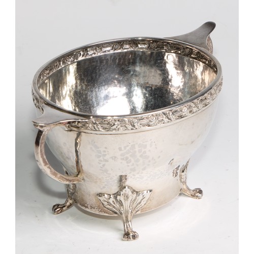 1139 - An Arts and Crafts silver three piece tea service, comprising teapot, hot water pot and sugar basin,... 