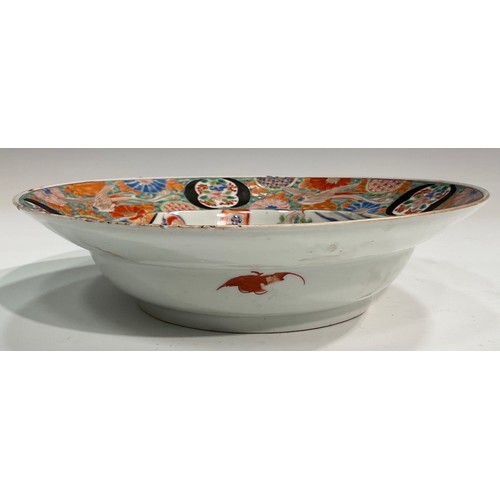 434 - A Japanese porcelain bowl, the central section painted with figures in traditional interior, surroun... 