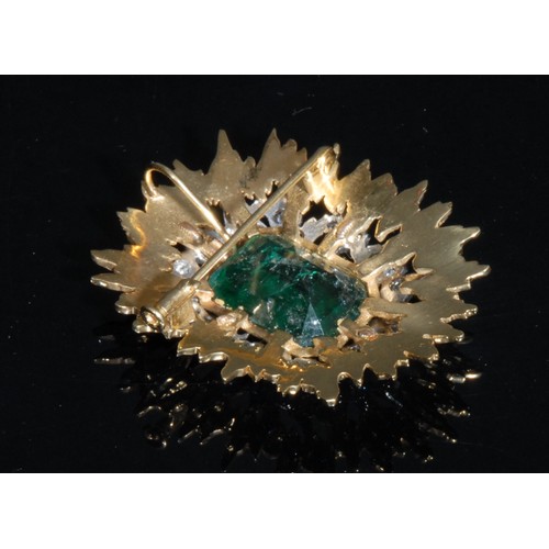 1520 - An emerald, diamond and gold coloured metal sunburst brooch, the large central cushion cut emerald w... 