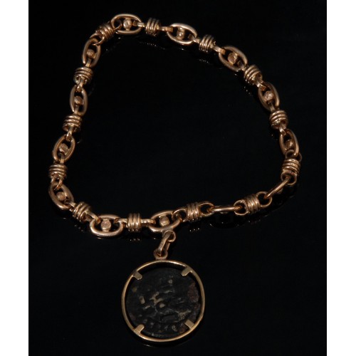 2639 - An ancient Arabic bronze coin, now mounted in a gold coloured metal fancy link bracelet, 21.9g overa... 