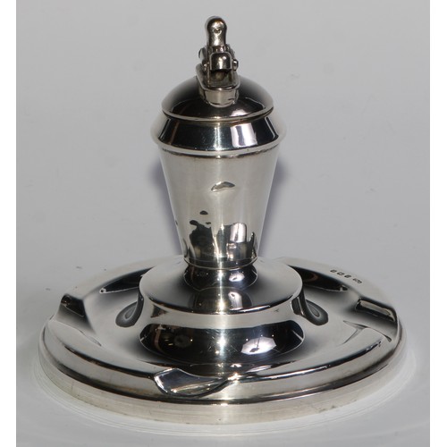 978 - A George V silver table cigar lighter, as a Roman lamp, flying scroll handle terminating in the head... 