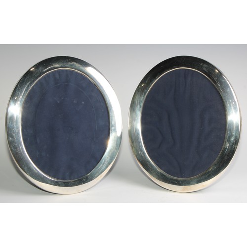 1023 - A pair of Elizabeth II silver oval easel photograph frames, quite plain, 30cm high, Sheffield 1988 &... 