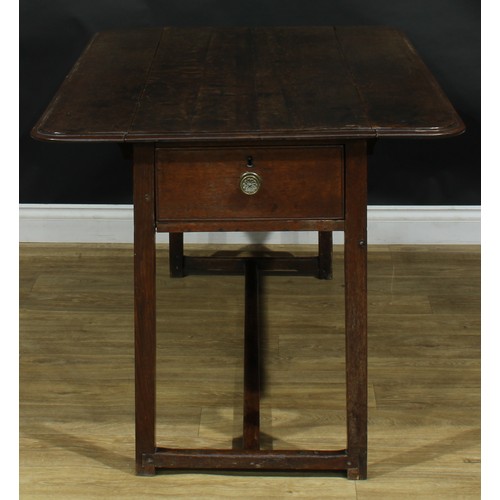 2043 - A George III vernacular oak servants' quarters Pembroke table, rounded rectangular top with fall lea... 