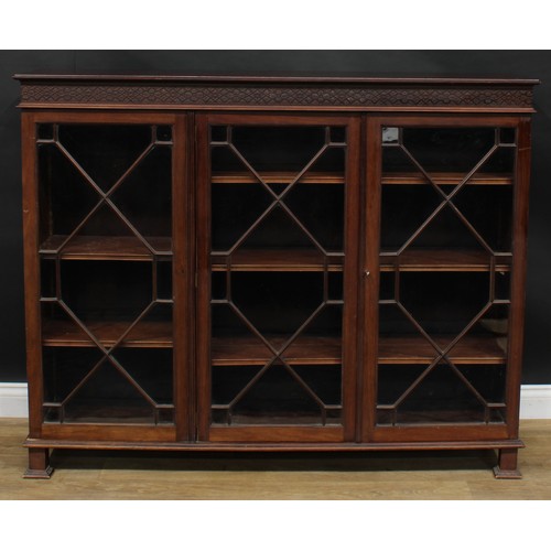 2443 - A Chippendale Revival mahogany low library bookcase, rectangular top above three glazed doors enclos... 