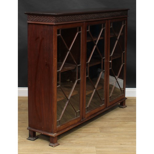 2443 - A Chippendale Revival mahogany low library bookcase, rectangular top above three glazed doors enclos... 