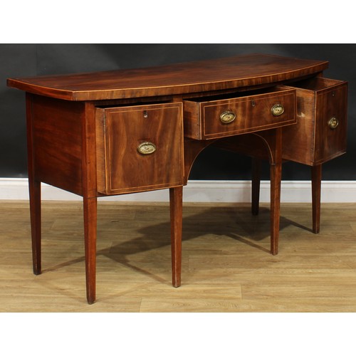 1786 - A George III mahogany bowfront sideboard or serving table, oversailing satinwood banded top above th... 