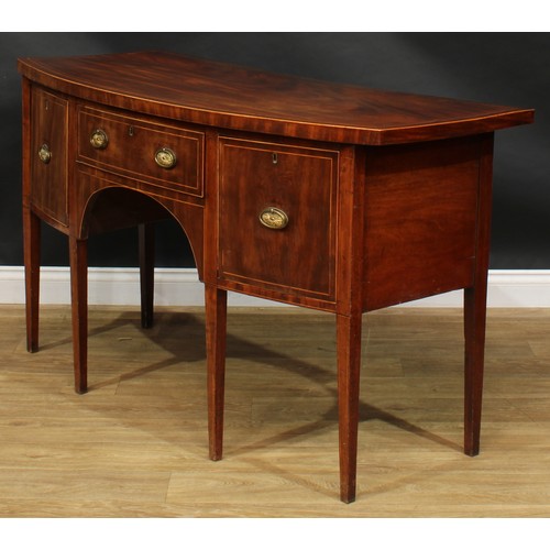 1786 - A George III mahogany bowfront sideboard or serving table, oversailing satinwood banded top above th... 