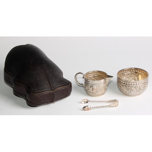 1092 - A Victorian silver milk jug and sugar bowl, repousse chased in the Indian taste with bands of geomet... 