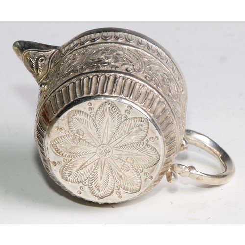 1092 - A Victorian silver milk jug and sugar bowl, repousse chased in the Indian taste with bands of geomet... 