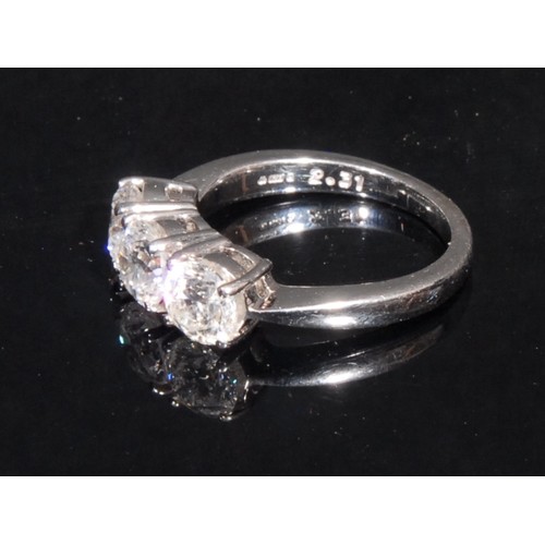 1446 - A three stone diamond and 18ct white gold ring, claw set with three round brilliant cut stones, each... 