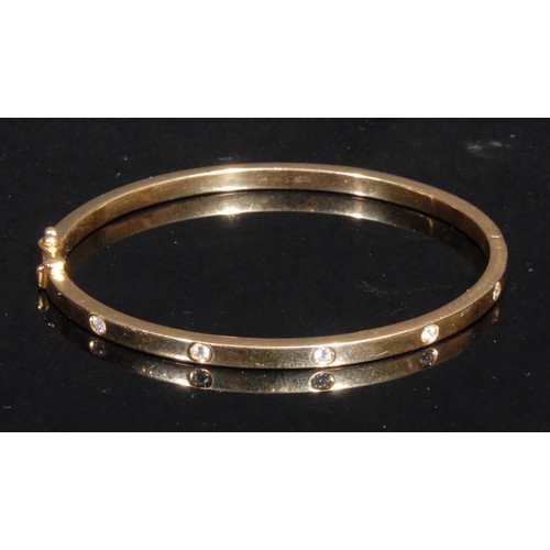 1374 - A diamond set hinged bangle, stamped '750' for 18ct gold, quite plain, set with five brilliant cut s... 