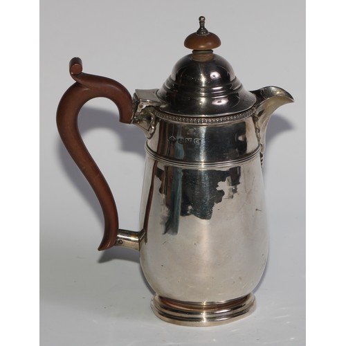 961 - A George V silver hot water pot, hinged domed cover with knop finial, scroll-capped handle, three-qu... 