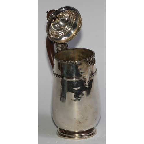 961 - A George V silver hot water pot, hinged domed cover with knop finial, scroll-capped handle, three-qu... 