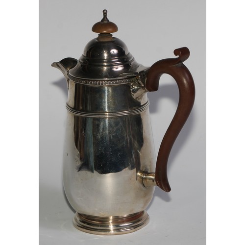 961 - A George V silver hot water pot, hinged domed cover with knop finial, scroll-capped handle, three-qu... 