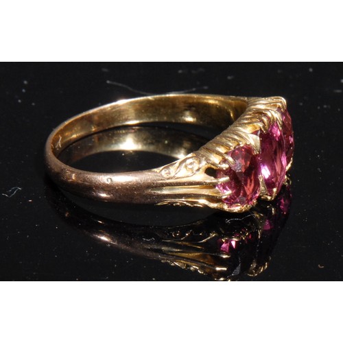 1470 - A Victorian style three stone ring, the graduated oval pink stones facet cut, yellow metal shank, si... 