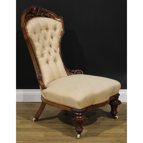 2291 - A Victorian walnut low drawing room chair, shaped cresting rail pierced and carved with bell husks, ... 