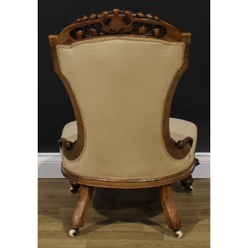 2291 - A Victorian walnut low drawing room chair, shaped cresting rail pierced and carved with bell husks, ... 