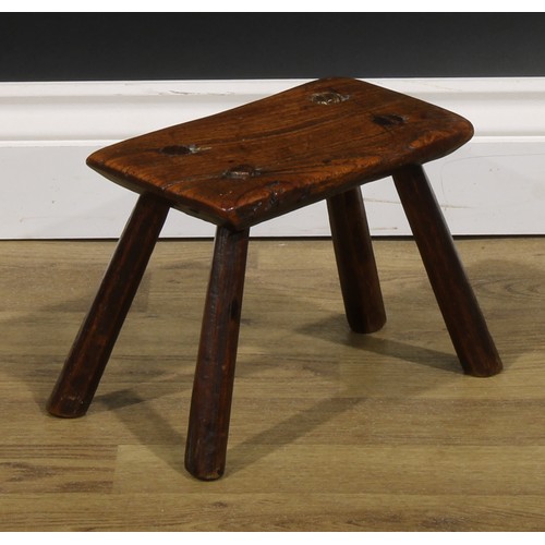 2054 - A late 18th/early 19th century elm milking stool, 19.5cm high, the top 24cm long and 14cm wide