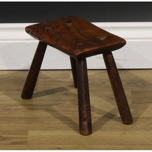 2054 - A late 18th/early 19th century elm milking stool, 19.5cm high, the top 24cm long and 14cm wide