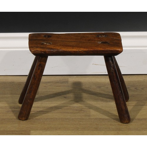 2054 - A late 18th/early 19th century elm milking stool, 19.5cm high, the top 24cm long and 14cm wide