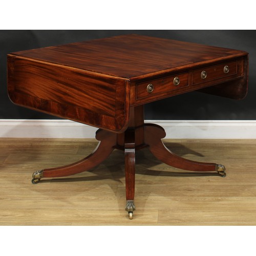 2231 - A Regency flame crossbanded mahogany sofa table, rounded rectangular top with fall leaves above a pa... 