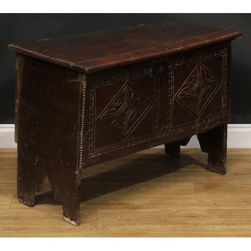 1568 - A 17th century elm six plank chest, hinged top enclosing a till, the front carved with leafy geometr... 