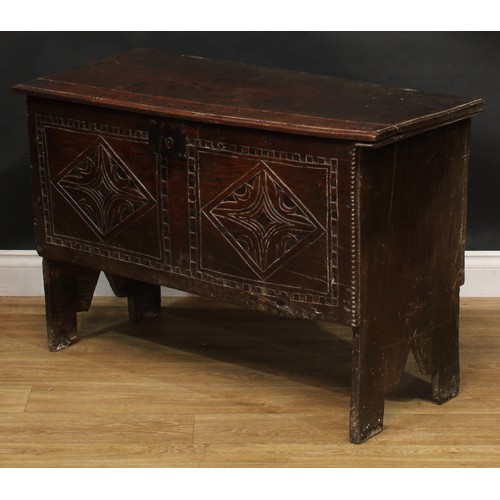 1568 - A 17th century elm six plank chest, hinged top enclosing a till, the front carved with leafy geometr... 