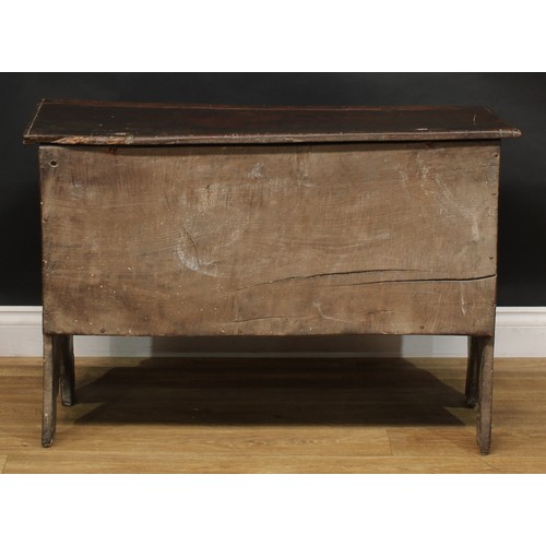 1568 - A 17th century elm six plank chest, hinged top enclosing a till, the front carved with leafy geometr... 