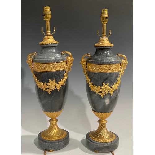 2023 - A pair of Louis XVI style gilt metal mounted marble table lamps, each applied with Bacchus masks and... 