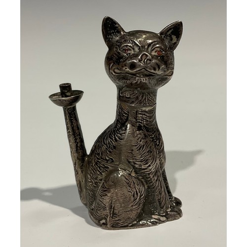 1155 - An Edward VII novelty table lighter as a grinning cat, 'Ruby' eyes, seated, the flame from his erect... 