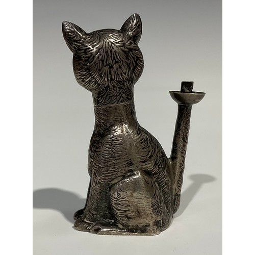 1155 - An Edward VII novelty table lighter as a grinning cat, 'Ruby' eyes, seated, the flame from his erect... 