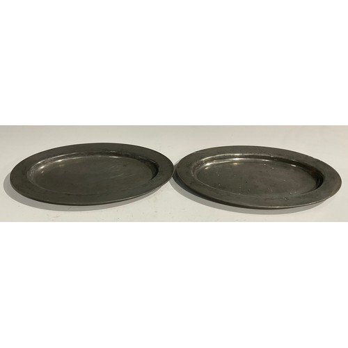 1810 - A pair of 18th century oval pewter plates, quite plain, broad rims, London touch marks, 35.5cm wide,... 