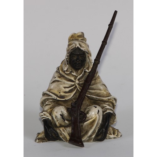 1680 - A cold painted bronze, of an Arab seated with a jezzail, 12cm high