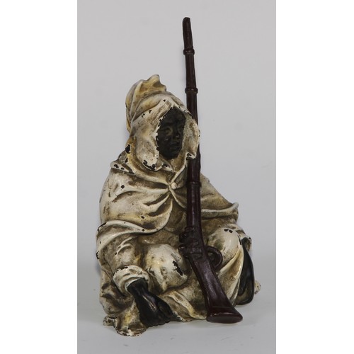 1680 - A cold painted bronze, of an Arab seated with a jezzail, 12cm high