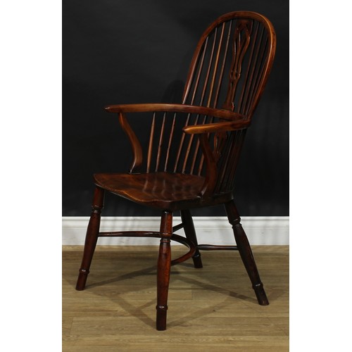 1642 - A 19th century yew and beech Windsor elbow chair, hoop back, shaped and pierced splat, one-piece mid... 