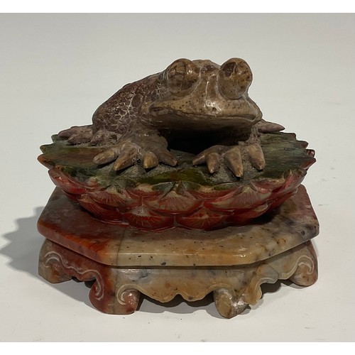 386 - A Chinese soapstone carving, of a toad, upon a lotus, octagonal base, 10cm wide