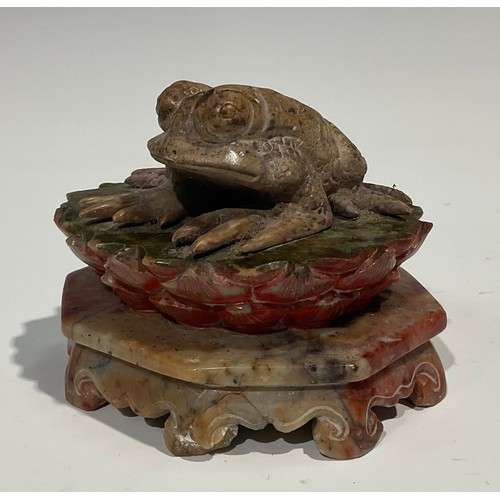 386 - A Chinese soapstone carving, of a toad, upon a lotus, octagonal base, 10cm wide