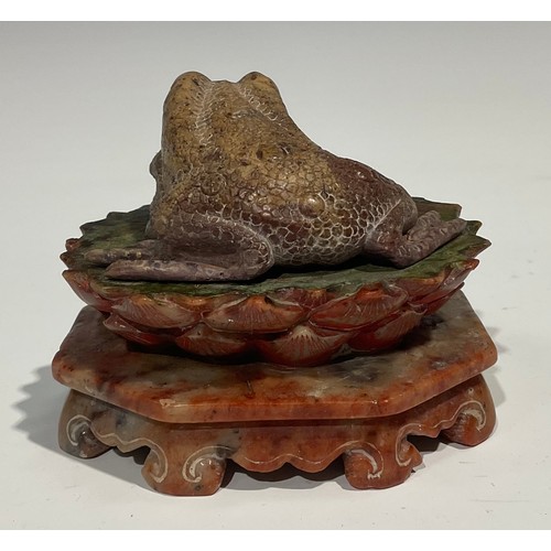 386 - A Chinese soapstone carving, of a toad, upon a lotus, octagonal base, 10cm wide