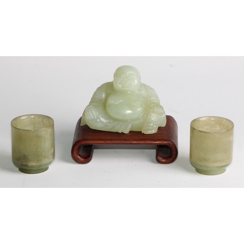 382 - A Chinese jade carving, of Budai, he sits, rotund, holding beads, 10cm wide, hardwood stand; a pair ... 