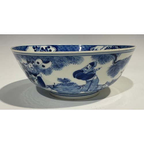 359 - A Chinese circular bowl, playing in tones of underglaze blue with figures in a monumental landscape,... 