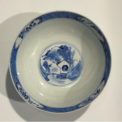 359 - A Chinese circular bowl, playing in tones of underglaze blue with figures in a monumental landscape,... 