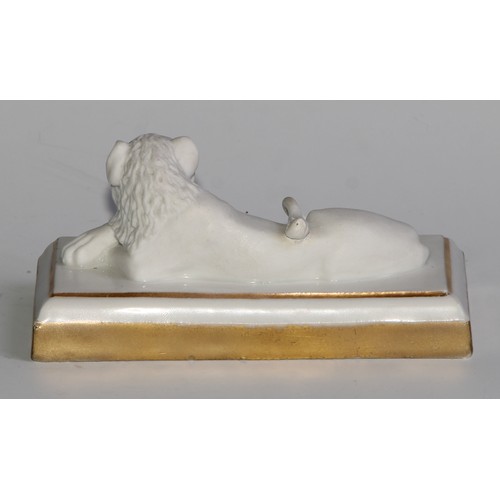 289 - A Dagoty porcelain model, of a recumbent lion, in the white with gilt borders, 11cm wide, red mark, ... 