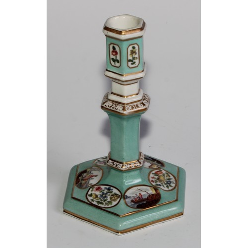 298 - A pair of Berlin hexagonal candlesticks, of silver shape, decorated in polychrome with landscape vig... 