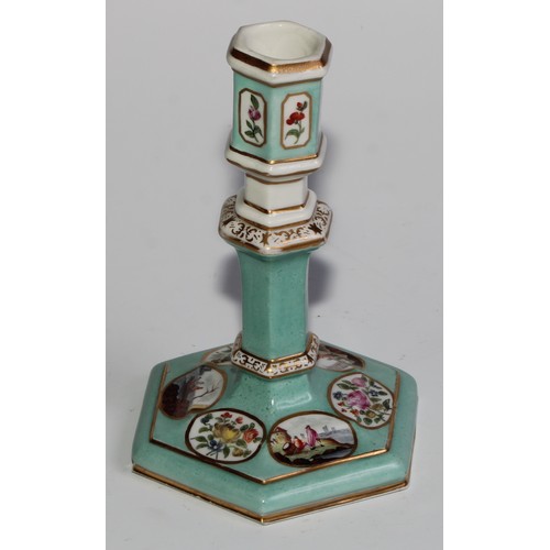 298 - A pair of Berlin hexagonal candlesticks, of silver shape, decorated in polychrome with landscape vig... 